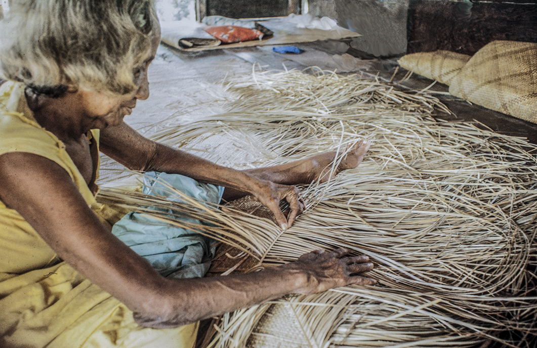 3149-15.jpg
 Working on pandanus leaf mat, that she is starting to plait.
 : Kapinga Village : Clayton Price Photographer